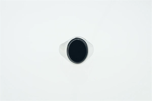 Macro detail of men's titanium steel signet ring with large oval black agate gemstone