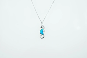 Detalle del colgante de caballito de mar con ópalo azul sobre una cadena de plata