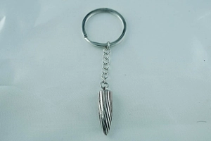 Close-up of silver titanium steel keychain with spiral textured cone pendant for men