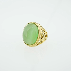 Bague vintage dorée avec une grande pierre verte ovale et des gravures ajourées fines