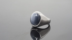 Detail of a vintage stainless steel ring featuring a large oval cat eye gemstone