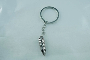 Macro detail of silver bullet-shaped titanium steel keychain with vertical textures