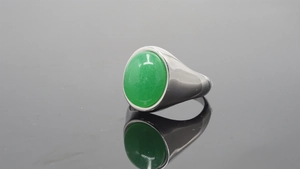 Close-up of a stainless steel ring featuring a large oval green jade cabochon gemstone