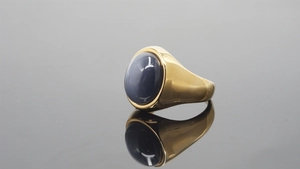 Polished gold stainless steel ring with a large oval blue gemstone and mirror reflection