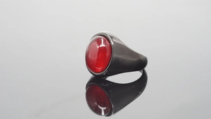 Close-up of vintage stainless steel black ring with a large oval red gemstone inlay