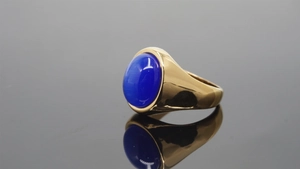 Macro shot of oval blue cat's eye gemstone set in a polished gold stainless steel ring