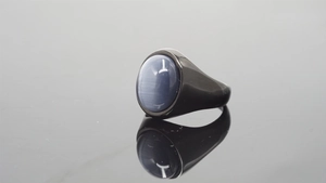 Macro shot of oval cat-eye gemstone ring with polished dark grey stainless steel band