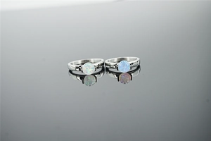 Close-up of ocean blue opal stone set in polished minimalist stainless steel silver rings