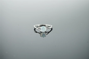 Vue détaillée d'une bague vintage en argent avec opale et design croisé ajouré sur reflet