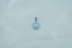 Macro detail of oval opal pendant with halo of white zircons on silver titanium necklace