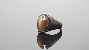 Macro view of a tiger eye stone ring set in a polished black stainless steel band