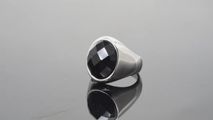 Macro shot of a polished silver signet ring with a large faceted black gemstone inlay