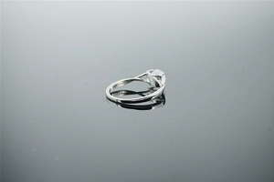 Détail macro d'une bague vintage en argent avec opale ronde sur une surface miroir noire