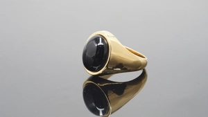 Macro shot of gold-plated stainless steel ring featuring a polished black onyx stone