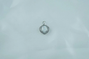 Detail of heart-shaped opal pendant featuring shimmering center stone and pavé accents
