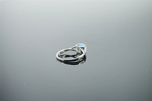 Vue détaillée d'une bague en argent polie ornée d'une pierre d'opale bleu clair ronde