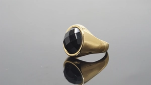Detail of a vintage gold signet ring featuring a large faceted oval black gemstone