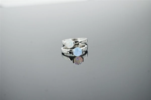 Macro shot of silver metal rings featuring round blue opal stones with vibrant fire