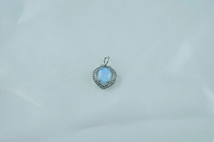 Close-up of heart-shaped opal pendant with diamond-encrusted silver border