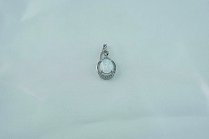 Macro shot of oval white opal pendant with sparkling fire effect in silver-toned setting