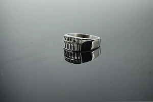 Macro detail of vintage steel abacus ring with rotatable beads on mirror surface