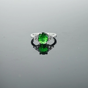 Elegant vintage silver ring featuring an oval green gemstone with white diamond accents