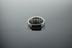 Detailed macro view of retro stainless steel abacus ring with movable beads on dark surface