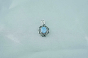 Detail of vintage titanium steel necklace featuring a blue opal pendant with a Greek key pattern