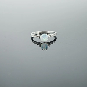 Minimalist silver steel ring with opal stone and sparkling side stones on a mirror base