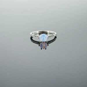 Elegant opal silver ring with light blue stone and pave diamonds on dark background