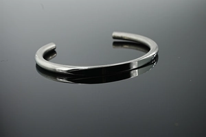 Detailed view of C-shaped stainless steel cuff bracelet with mirror-polished silver finish