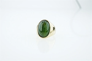 Dettaglio dell'anello vintage dorato con una grande pietra ovale verde occhio di gatto