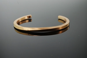 Macro view of Mobius cuff bracelet with a brushed matte finish and geometric twisted design