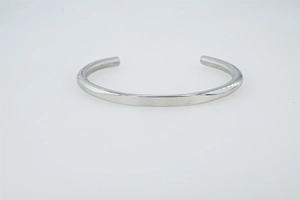 Detail showing the polished silver C-shaped groove bangle with a high-gloss metallic finish