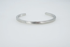 Detailed macro view of silver Mobius cuff bracelet featuring brushed steel texture