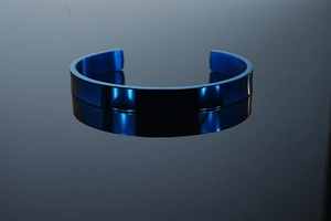 Detail view of the brushed dark blue stainless steel cuff bracelet with mirror reflection