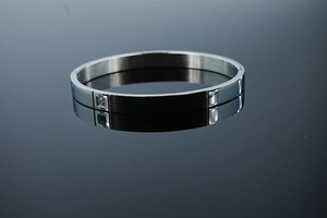 Détail d'un bracelet jonc minimaliste argenté avec pierre carrée et texture brossée