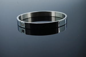 Détail d'un bracelet ovale argenté avec insert noir et pierre de zircon scintillante