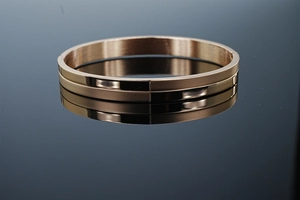 Detailed close-up of 8mm rose gold stainless steel bangle with brushed and polished finish