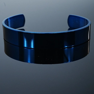 Polished blue stainless steel cuff bracelet with a mirror finish on a reflective background