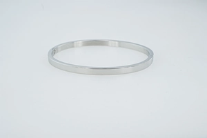 Gros plan d'un bracelet jonc minimaliste en acier argenté avec finition lisse polie