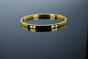 Détail d'un bracelet jonc doré minimaliste avec une finition miroir polie brillante