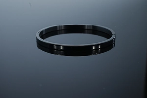 Vue macro d'un bracelet jonc minimaliste en acier inoxydable noir au poli miroir