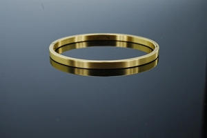 Gros plan détaillé du bracelet jonc doré en acier brossé avec fermoir à charnière
