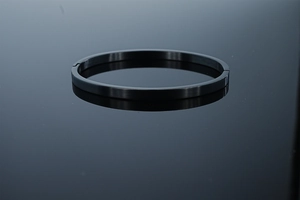 Détail d'un bracelet en acier inoxydable noir mat avec fermoir à charnière et texture brossée