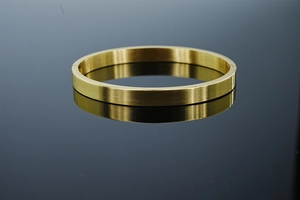Détail d'un bracelet ovale en acier inoxydable brossé doré avec fermeture à charnière sur noir