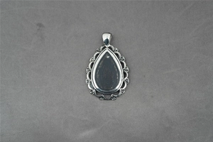 Vue macro d'un pendentif goutte en argent vintage avec filigrane et pierre noire