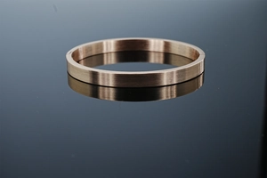Vue macro d'un bracelet en acier inoxydable rose gold avec texture brossée et charnière