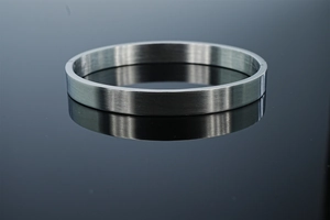 Détail de la texture en métal brossé et fermoir minimaliste du bracelet en acier