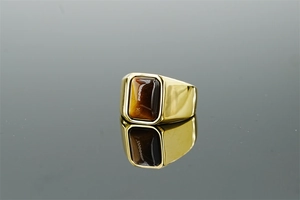 Macro view of rectangular tiger eye stone set in a wide gold stainless steel ring band